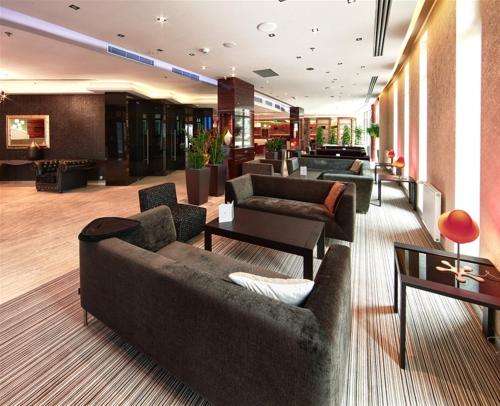 a lobby with couches and tables in a building at Holiday Inn Trnava by IHG in Trnava