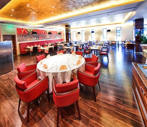 a dining room with a table and red chairs at Holiday Inn Trnava by IHG in Trnava
