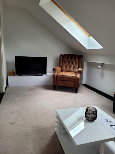 a living room with a chair and a television at gemütliche Ferienwohnung in Burgstaedt