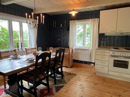 une cuisine avec une table en bois et une salle à manger dans l'établissement « SoFly Cottage », le charme pur, à Noresund