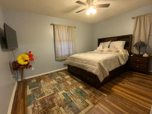 um quarto com uma cama e uma ventoinha de tecto em The Sunshine House em Midwest City