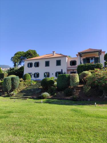 a large white house with a grass yard at Quinta São Gonçalo in Funchal