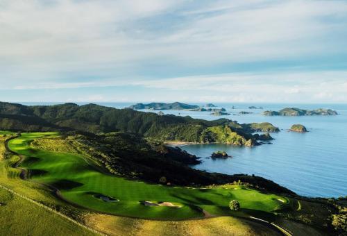 an aerial view of a golf course with the ocean at Kerikeri Park Lodge in Kerikeri