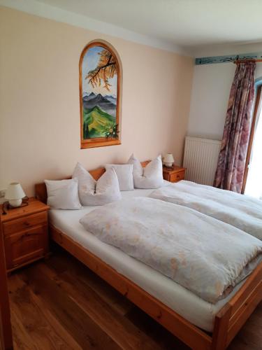 a bedroom with a large bed and a painting on the wall at Landhaus Müller in Jungholz