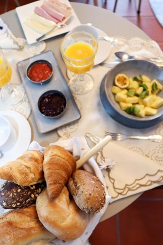 a table with a plate of bread and pastries on it at Quinta São Gonçalo in Funchal