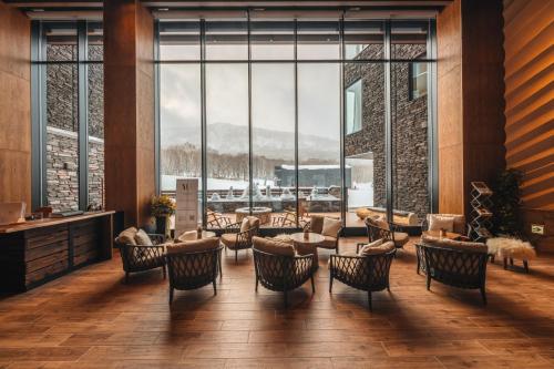 a lobby with chairs and tables and large windows at Yu Kiroro, Ski-in Ski-out Luxury Residences in Akaigawa