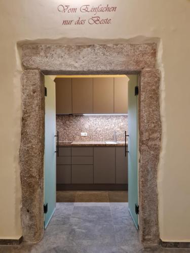 an entrance to a kitchen with a stone wall at Stadtpalais Marché-Suite maximal 2 Personen und 1 Kleinkind in Bautzen