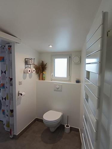 une salle de bain blanche avec toilettes et fenêtre dans l'établissement Studio en Provence avec accès à la piscine de la propriété, à Velleron