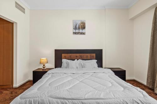 1 dormitorio con 1 cama grande con sábanas blancas en Ruby Residence- Cozy 1BHK Apartment with Balcony in Silicon Oasis, en Dubái