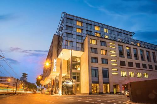 a tall building on a city street at night at Dorint Hotel am Heumarkt Köln in Cologne