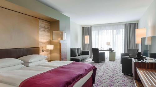 a hotel room with a bed and a desk at Dorint Hotel am Heumarkt Köln in Cologne