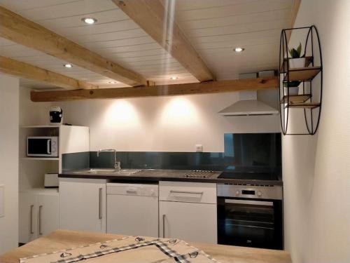 uma cozinha com armários brancos e um forno com placa de fogão em La Casa de Pimpele em Saint-Martin