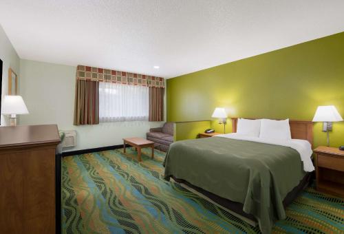 Habitación de hotel con cama y sofá en Quality Inn & Suites Medford Airport, en Medford