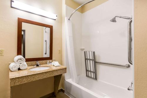 a bathroom with a sink and a tub and a mirror at Comfort Inn & Suites IAH Bush Airport – East in Humble