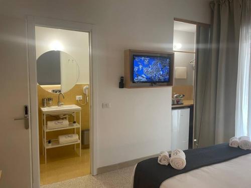 a bedroom with a tv on the wall and a bed at Ciccio Rooms and breakfast - Self check-in in Palermo