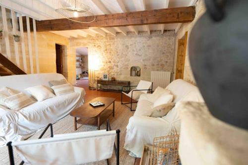 una sala de estar con sofás blancos y una mesa. en TERRE DE VIGNES,Détente - Piscine - Grands Espaces, en Génissac
