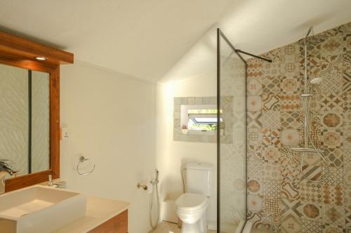 a bathroom with a toilet and a sink and a shower at Serenity by the Sea- 3BRVilla w Stunning Sunsets in Tamarin