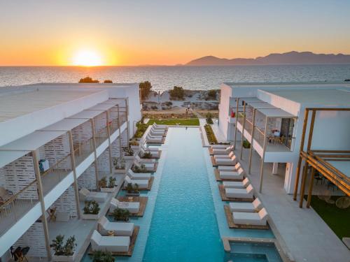 an aerial view of a hotel with a pool and the ocean at Paralos Kyma Dunes Adults Only in Mastihari