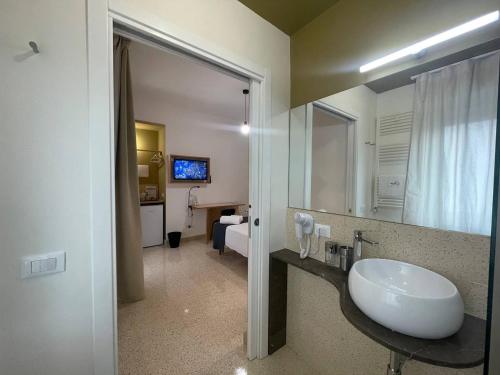 bagno con lavandino e grande specchio di Ciccio Rooms and breakfast a Palermo