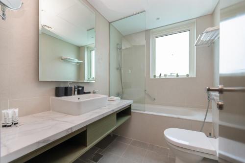 a bathroom with a sink and a toilet and a mirror at Stylish Apartment With Incredible Canal Views in Dubai