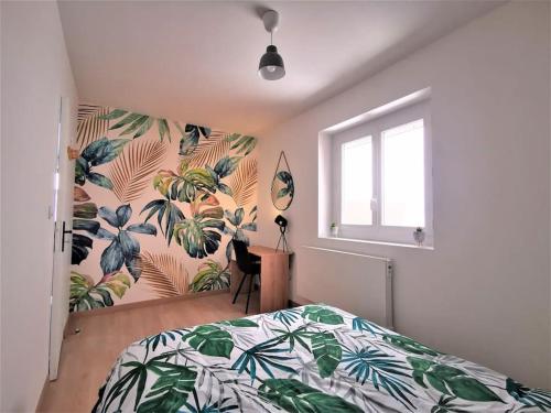 ein Schlafzimmer mit einem Bett mit einer tropischen Tapete in der Unterkunft Le T3 Confort - Au Cœur de Montceau in Montceau-les-Mines
