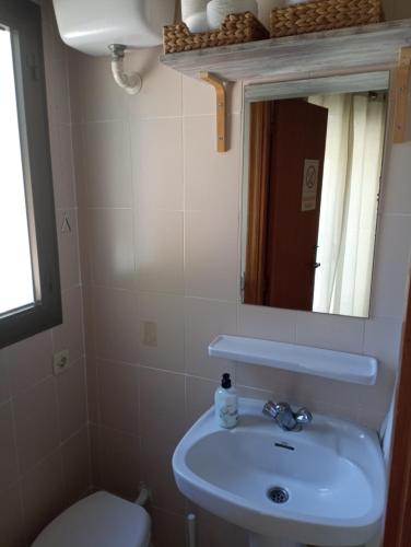 a bathroom with a sink and a toilet and a mirror at Estudio Caballo-Piscina in Denia