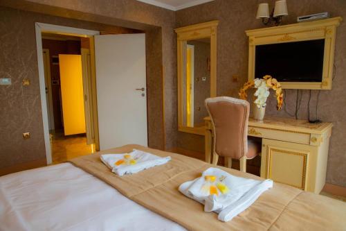 a bedroom with a bed with towels on it at Luxury Apartment 'Rich' in Velingrad