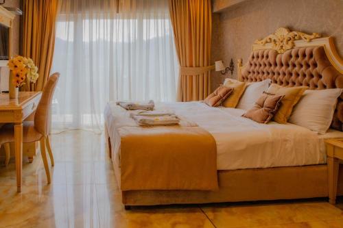 a bedroom with a large bed with a desk and a window at Luxury Apartment 'Rich' in Velingrad