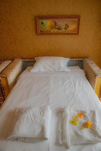 a large white bed with two towels on it at Luxury Apartment 'Rich' in Velingrad