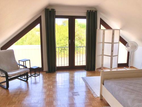 1 dormitorio con 1 cama, 1 silla y 1 ventana en Ferienwohnung Skandi, en Bad Eilsen