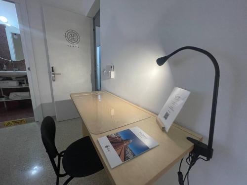 a desk with a lamp and a chair in a room at Ciccio Rooms and breakfast - Self check-in in Palermo