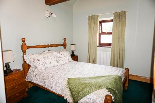 1 dormitorio con cama y ventana en Gars Cottage - 3 Bedroom Holiday Home, en Kirkby Stephen