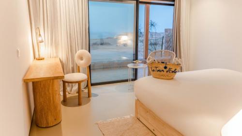 - une chambre avec un lit et une grande fenêtre dans l'établissement La Tour d'Eole, à Dakhla