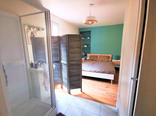 - une chambre avec un lit et une salle de bains avec un miroir dans l'établissement Le T1 Confort - Au Coeur de Montceau, à Montceau-les-Mines