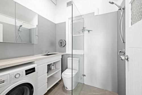 a white bathroom with a toilet and a shower at Double Room In Maroubra in Sydney