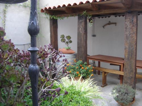 a garden with a wooden table and a bench at Casa Rural "La Bardena Blanca I " in Arguedas