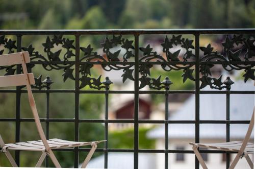 two chairs sitting on a balcony with a fence at Majestic T2 calme, spacieux, central, avec parking in Chamonix-Mont-Blanc