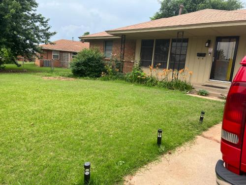a house with a yard with parking meters in the grass at The Sunshine House in Midwest City