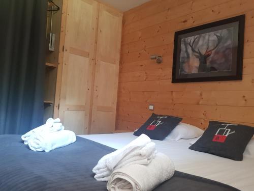 a bedroom with two beds with towels on them at bel appartement , son jardin et le lac in Chamonix-Mont-Blanc