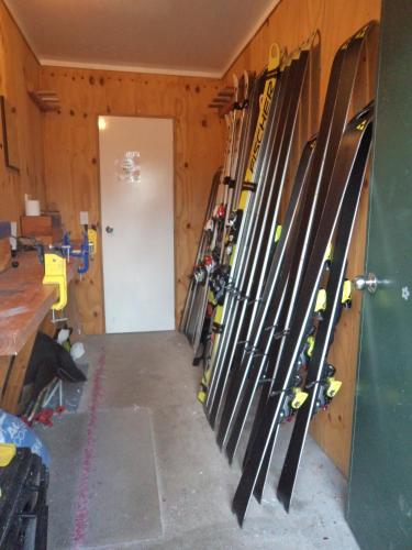 a bunch of skis are lined up against a wall at Tailor Made Tekapo Accommodation - Hostel in Lake Tekapo