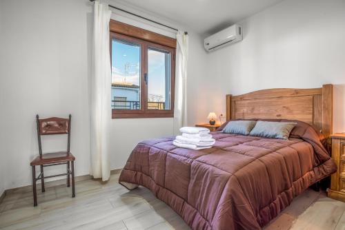 1 dormitorio con 1 cama, 1 silla y 1 ventana en Apartamentos turísticos rurales Camino Río Peralta, en Pozo Alcón