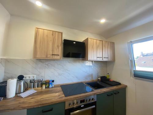 a kitchen with wooden cabinets and a counter top at Lux Apartment near Frankfurt! in Mörfelden-Walldorf