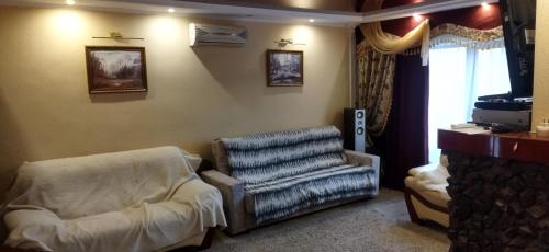 Villa في بيشكيك: غرفة معيشة فيها كرسي وتلفزيون
