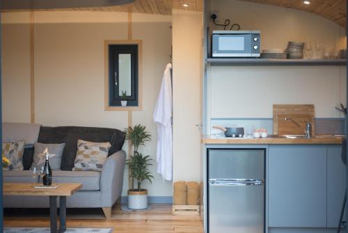 a living room with a couch and a table at Fern - Beacon View Pods in Knighton