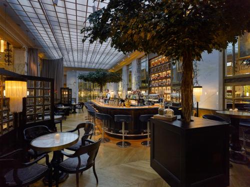 a restaurant with a bar with tables and chairs at Park Hyatt Vienna in Vienna