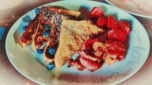 a plate of food with french toast and strawberries at Kukummi Lodge - formerly Mackaya Bella Country Lodge in Champagne Valley