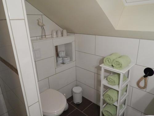 a small bathroom with a toilet and green towels at Grit´s Ferienwohnung in Ostseebad Karlshagen