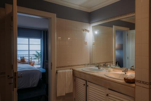 a bathroom with two sinks and a large mirror at Quinta São Gonçalo in Funchal