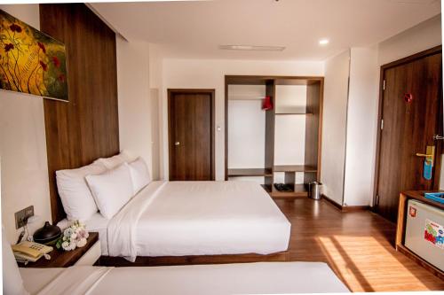 a hotel room with a bed and a television at Gold Central Hotel by Haviland in Da Nang