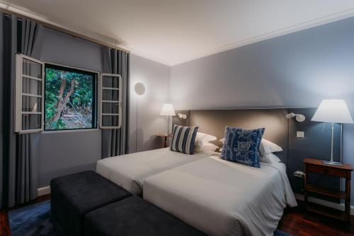 um quarto de hotel com uma cama e uma janela em Quinta São Gonçalo no Funchal